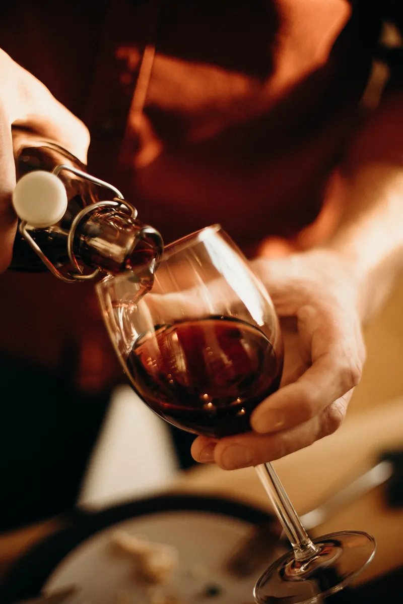 Sirviendo una copa de vino tinto